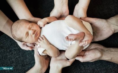asgeboren baby slapend in de handen van papa en mama tijdens newbornshoot bij Silvisual in Waalwijk