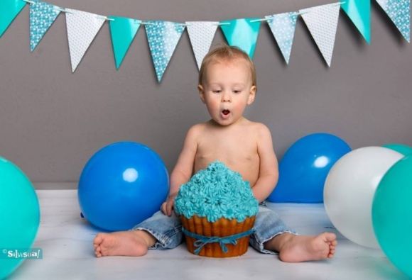 1 jaar feestje met turquoise smash cake en blauwe ballonnen tijdens cake smash fotoshoot bij Silvisual